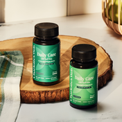 Product Image for Two bottles of Daily Care supplements on a wooden surface.