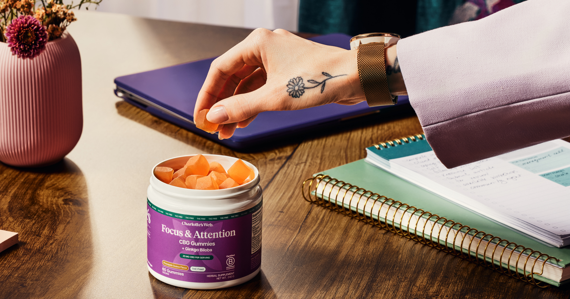 Hand taking gummies out of purple focus and attention gummies container