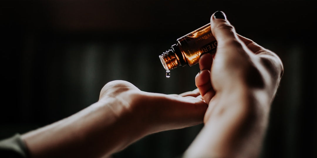 Person applying essential oil drops to hand