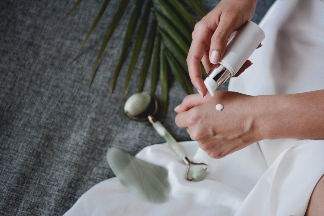 Applying moisturizer with jade roller and palm leaf