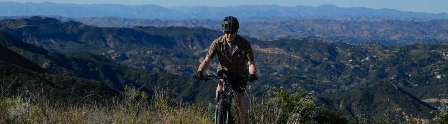 A person on a bike riding through a mountain landscape.