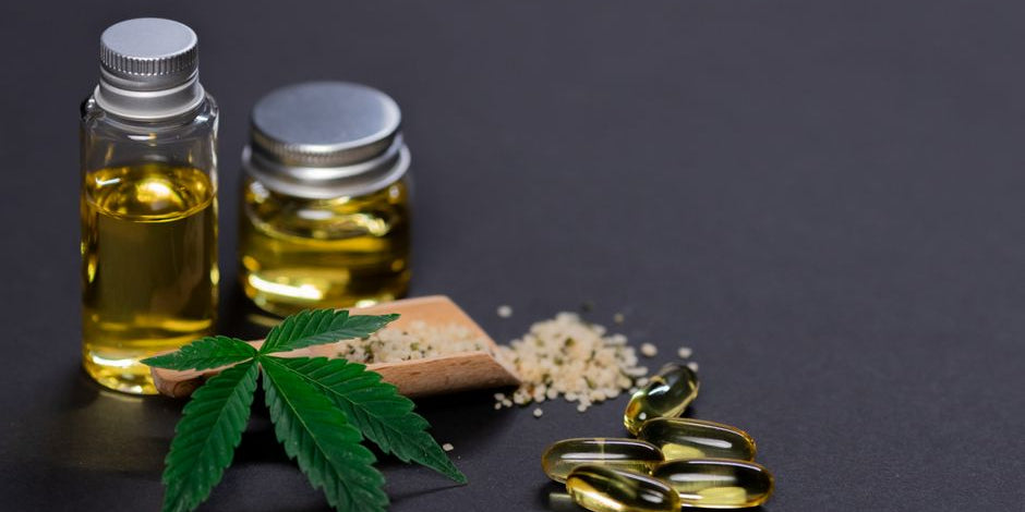 CBD oil bottles capsules hemp leaf and seeds