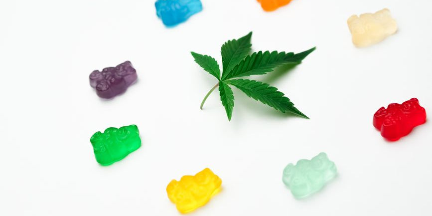 Cannabis leaf surrounded by colorful gummy bears