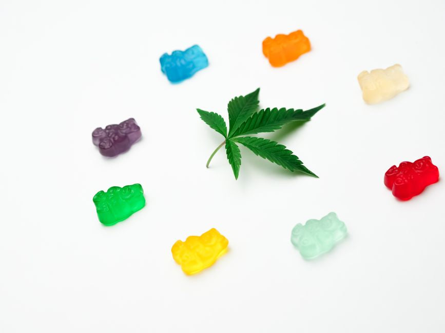 Cannabis leaf surrounded by colorful gummy bears
