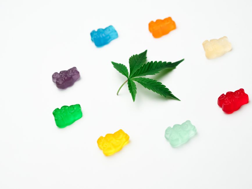 Cannabis leaf surrounded by colorful gummy bears
