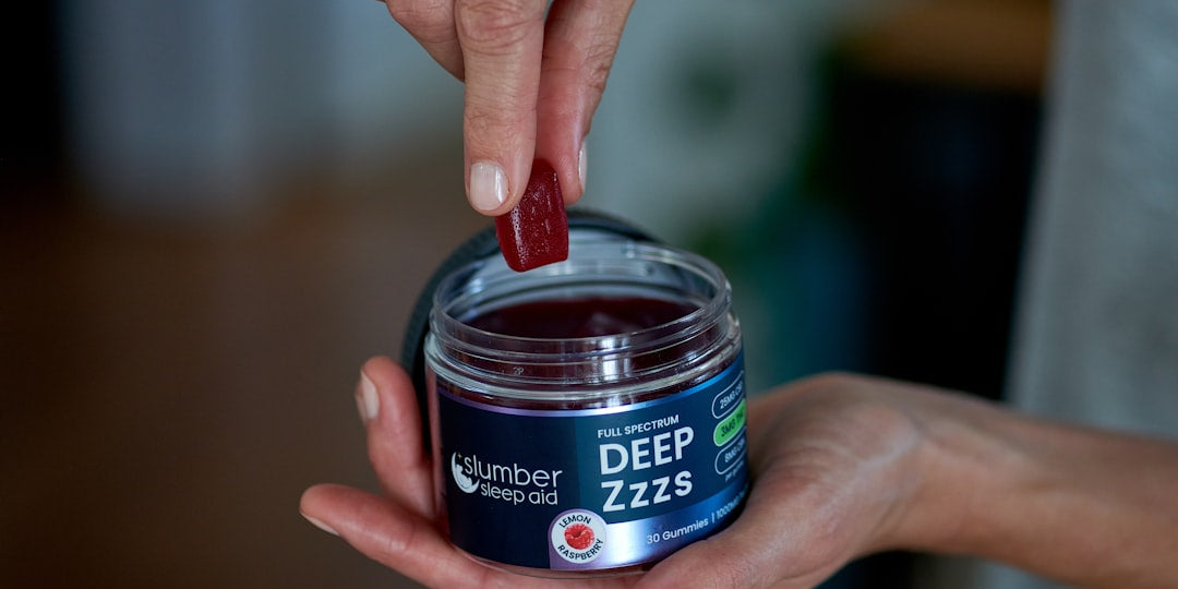 Hand taking gummy from Deep Zzzs sleep aid jar