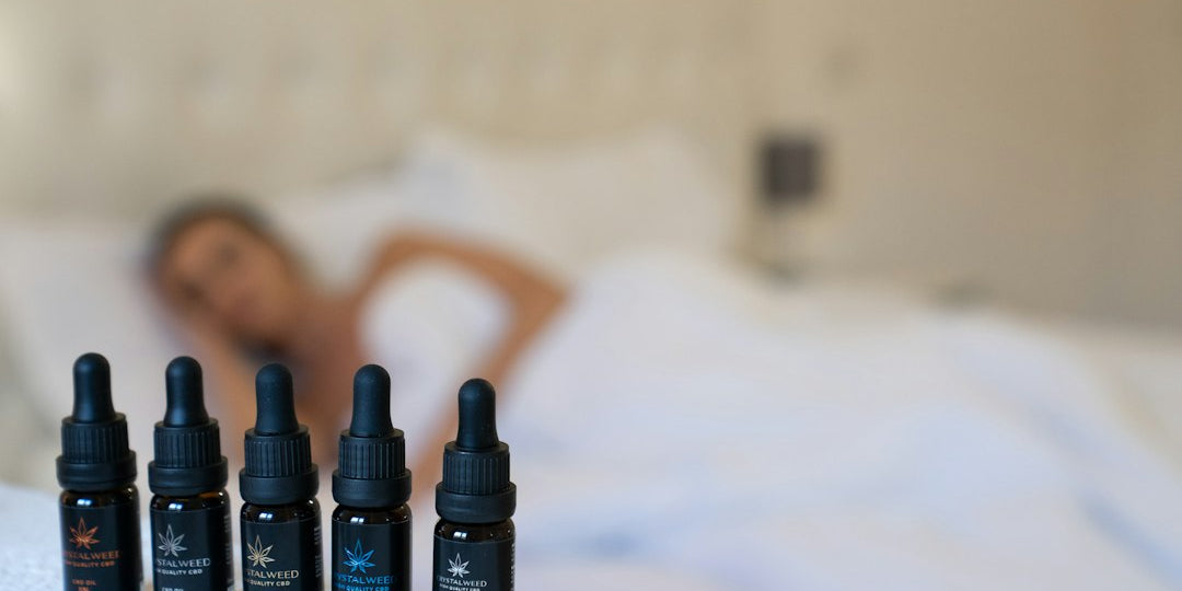 Five CBD oil bottles near a bed