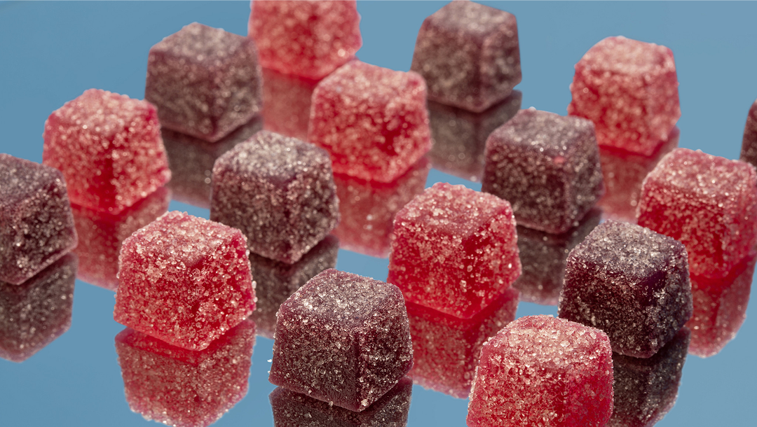 Red and brown gumdrop candies on a blue background