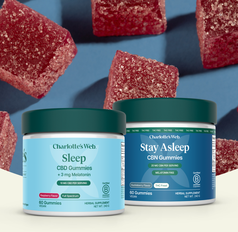 Two containers of Charlotte's Web gummies on a blue background with scattered gummies.