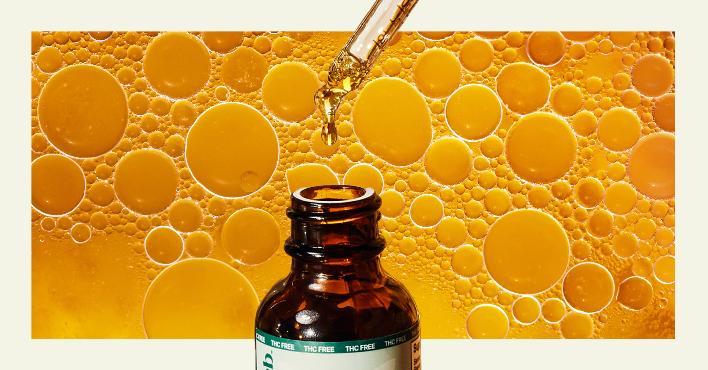 Bottle of oil with dropper on a yellow bubble background