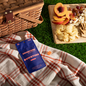 Product Image for Tea set with teapot, glass, and Charlotte's Web Brightside Downtime gummies packages on a wooden tray.