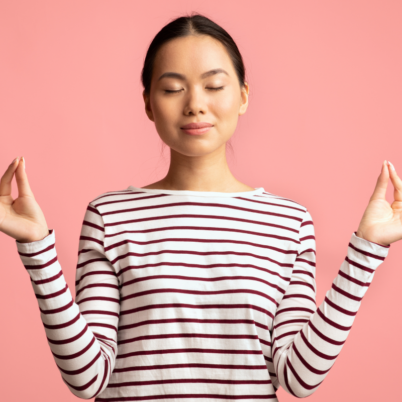 Woman wearing a striped shirt against a pink background