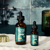 Product Image for Two bottles of Charlotte's Web Original Formula CBD Extract Oil on a marble surface with a tiled wall background.