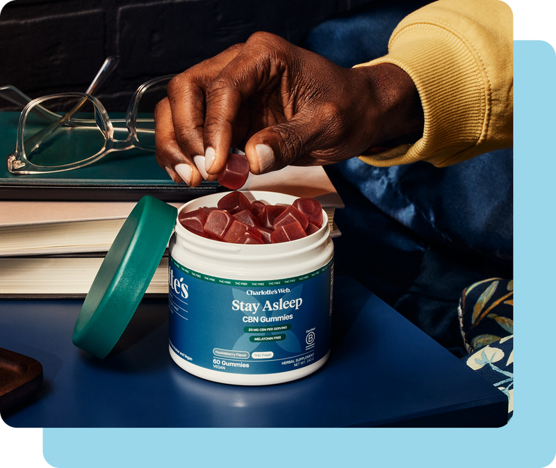 Person holding a supplement container labeled 'Stay Asleep' with a blue background