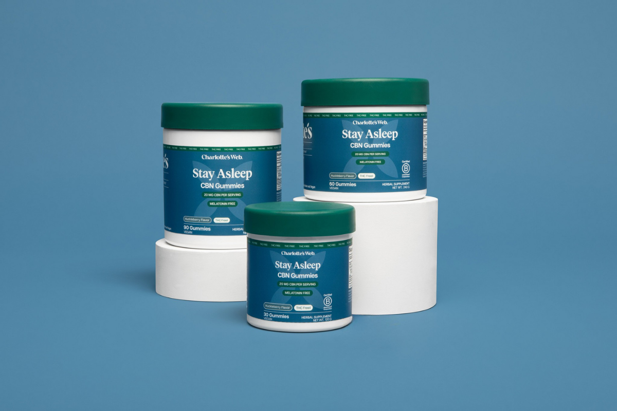 Three containers of 'Stay Asleep' supplement on a blue background