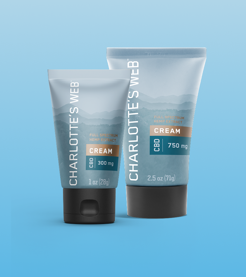 Two tubes of Charlotte's Web CBD cream on a blue background