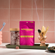 Product Image for Pink package labeled &#39;UNWIND&#39; on a tray with a pink tiled wall background