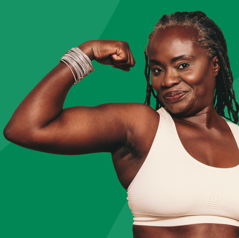 Woman flexing her arm muscles against a green background